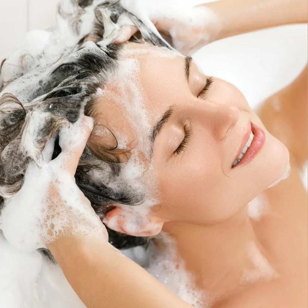 Woman washing her hair with SM Body Care's natural and organic argan oil shampoo.