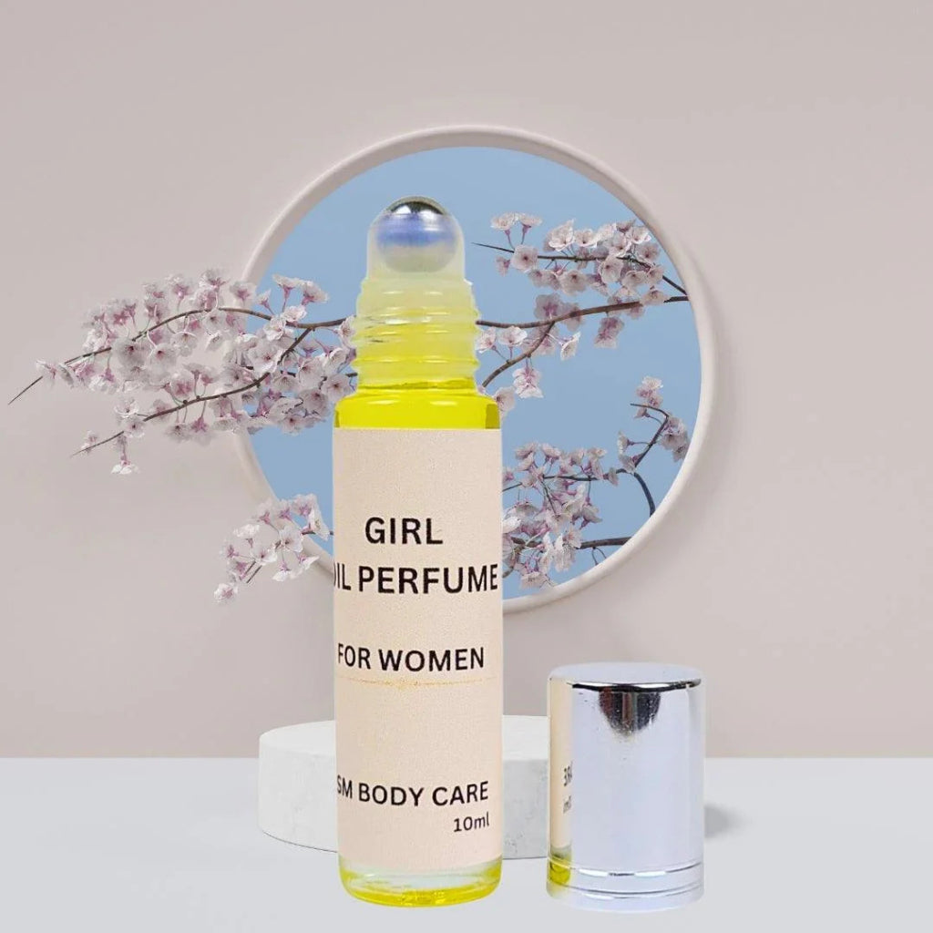 A bottle of 'GIRL OIL PERFUME' for women, accompanied by a small spray bottle, displayed on a table with a background of a mirror and flowers.